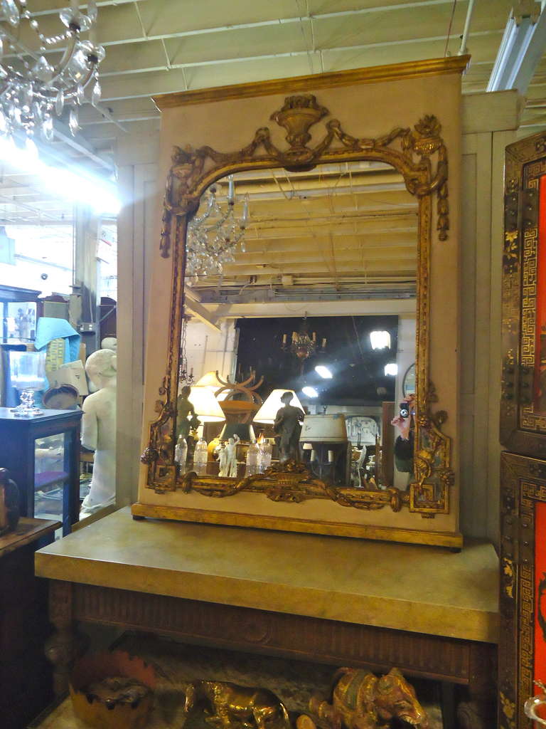 Very large and elegant trumeau mirror in cream painted wood and gilded embellishments.  Aged mirror in two panels.
46