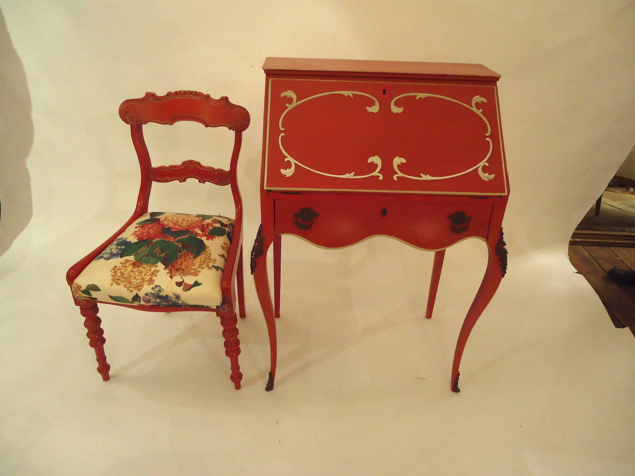 French slant front desk hand painted tomato Red and white with accompanying chair.  Bronze ormalu mounts, drawers and cubbies within.  When open, work surface is 18.5 D.