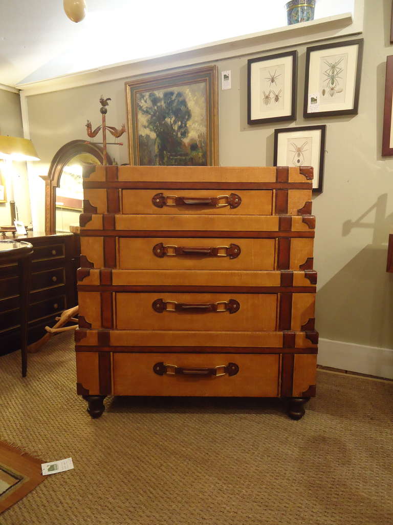 Clever chest of drawers designed out of four stacked suitcases, each with a single drawer.  On wooden bun feet.
