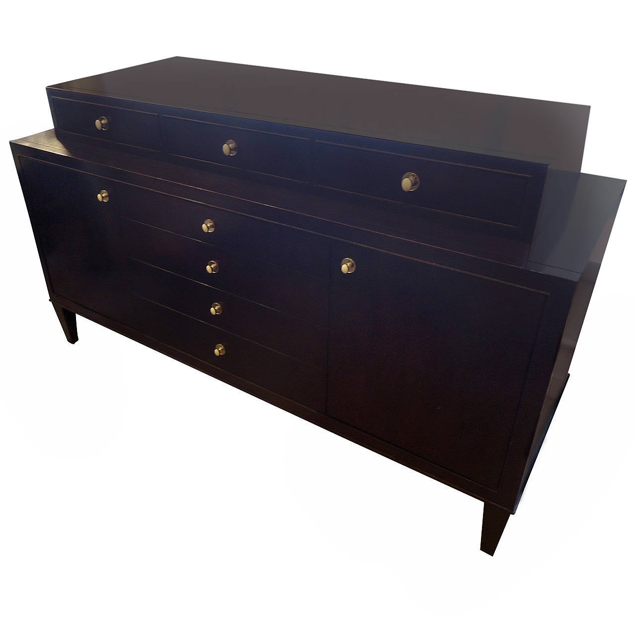 Very sophisticated and functional sideboard in ebonized wood with oval nickel silver and white enamel hardware. Two levels. Top level has three drawers, and sits on top of the lower commode which has two doors on each front side that open to