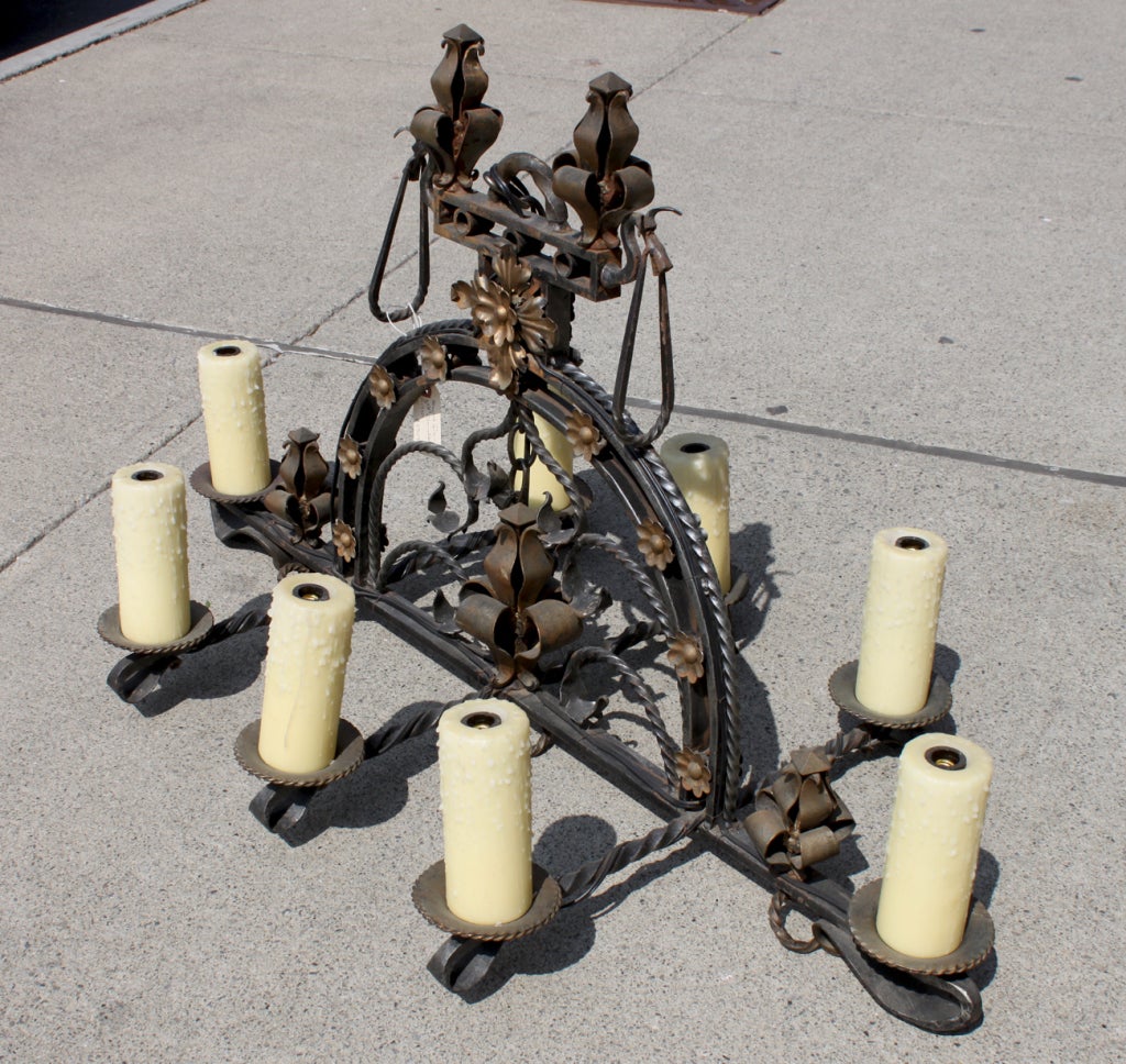 Beautiful iron chandelier with gilt flower details. Large wax drip molded candle covers. Pair of matching 2 light sconces also available.