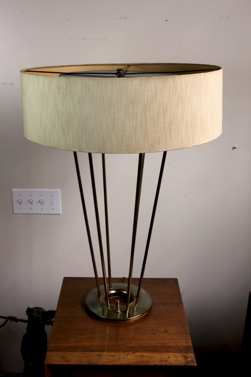 Large scale Brass Table Lamp with all original parts. 6 brass rods flaring upward from a brass ring supporting a black painted reflector covering 3 sockets which supports the original 22.5