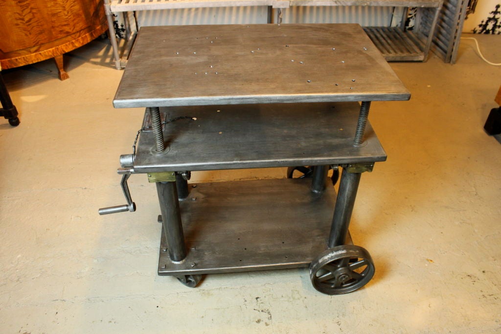 1920s steel adjustable 3 tier work table with original crank handle. locking wheel mechanism. beautifully restored surfaces.

mfg by Robert E Morris Co. West Hartford CT

price is for one