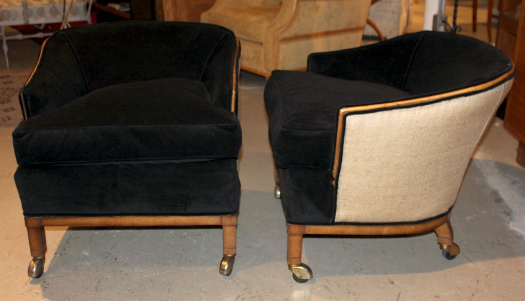 A wonderful pair of very stylish down-filled barrel back chairs. Elegant in design with exposed walnut frame. Brass castors adorn the legs. Comes with pair of tiger fabric pillows.