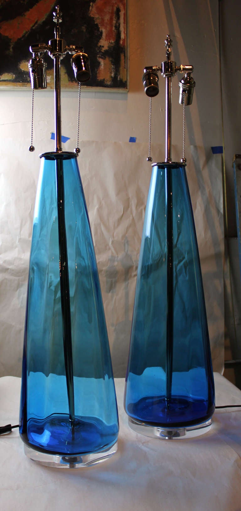 Pair of hand blown blue blenko table lamps. Ribbed with nickel hardware.