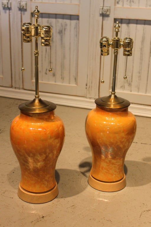 Lovely pair of iridescent gold/orange table lamps on wooden base.