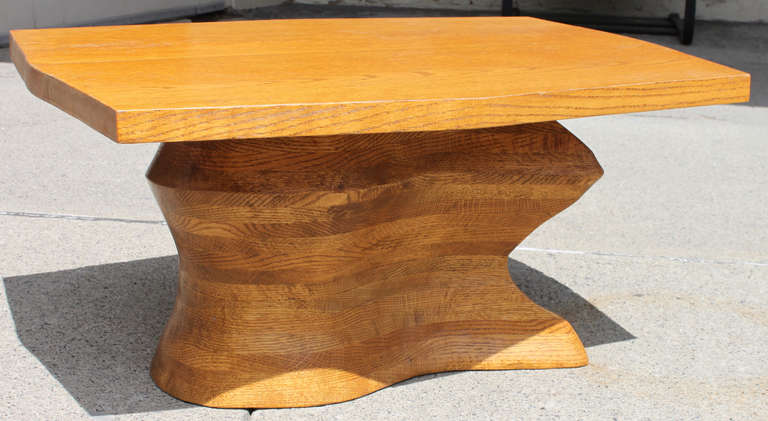 A biomorphic stacked oak laminate cocktail table. A two plank soft octagonal oak top sits above a biomorphic shaped pedestal comprised of several 1
