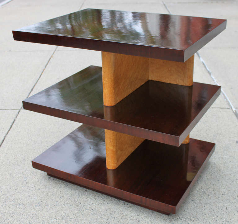 A truly elegant yet simple example of Szoeke's modernist design. This is a three tiered side table comprised of mahogany shelves that float through a column of birds eye sycamore. Beautifully restored, this piece is equally beautiful and purposeful .