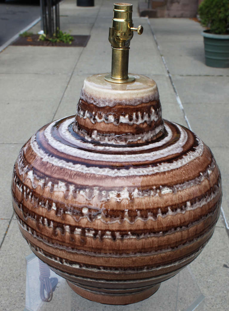 A large scale bulbous table lamp. Executed in a ringed palette of earth tones with an over glazed Craquellure. Newly required with silk cord and brass socket.