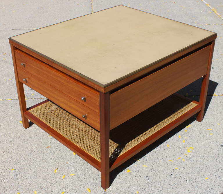 Paul McCobb Irwin Collection for Calvin. A wonderful mahogany occasional table with two drawers caned lower shelf and buff colored leather top with brass trim.