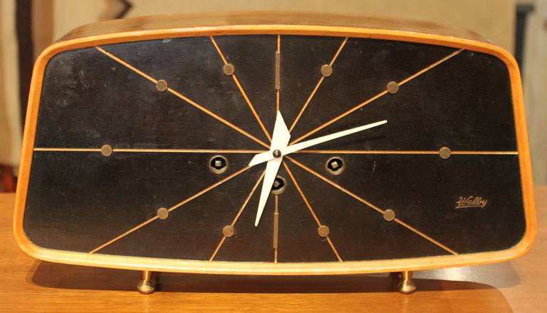 Beautiful Mid-Century Modern clock by Welby. It chimes and keeps good time. Walnut case with ebonized face. Brass hardware.