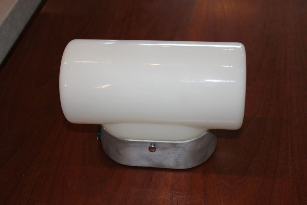 10 early mid century signed Lightolier brushed aluminum wall sconces with beautifully molded white milk glass shades. Quality of shades is excellent possibly Italian glass. Oval aluminum housing has a single electrical outlet in black and most have