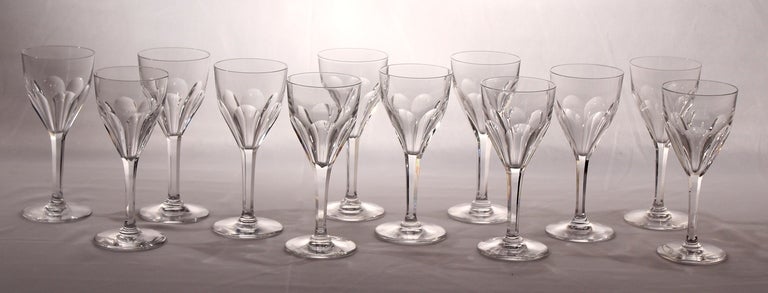 Saint Louis is the oldest crystal glass manufacturer in Continental Europe.(18th C.) It's part now of Hermes group.

These 12 wine glasses have  large flat sides  that form the 