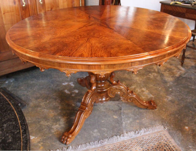 Large round table with a wonderful French walnut veneered top having a Rayonnant design and a crenelled cincture. It rests on a central baluster shaped pedestal terminated by three scrolled feet ending with Lion's claws.
Can seat six people.