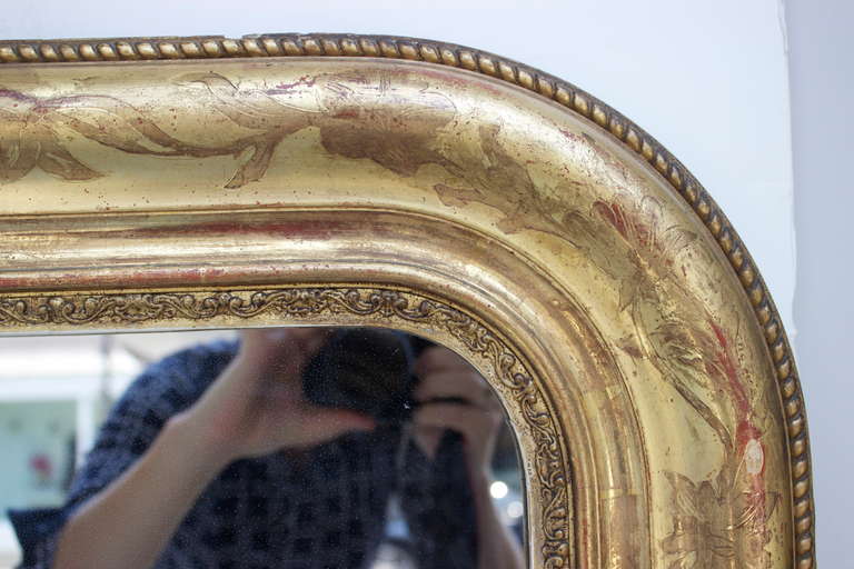 Louis-Philippe Period Water Gilt Mirror with a beautiful carved floral motif on the molding, and a stylized carved small cord on the outside edge.  There is also a very fine decor of leaves on the inside edge surrounding the glass which makes this