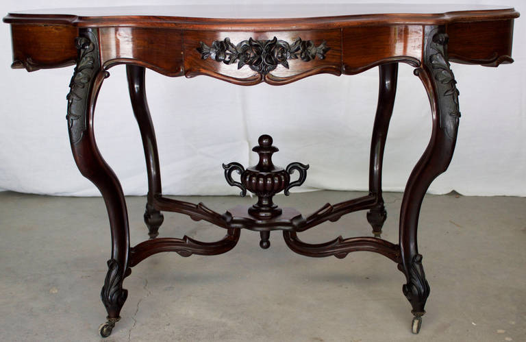 Remarkable craftsmanship for this table in Honduras rosewood veneer on solid mahogany as well as solid Ebonized mahogany. The top has a 