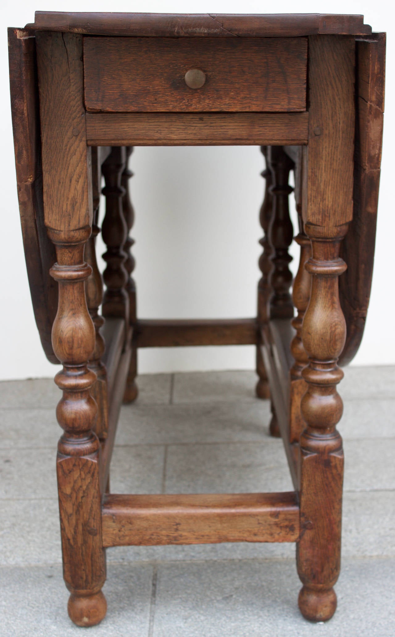 Fine French gateleg table entirely handmade with twin flaps and one drawer. Beautifully turned feet and lovely patina. Can be used as dining table, breakfast table, center table or behind a sofa.