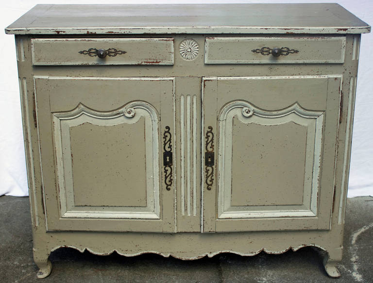 Handmade and wood pegged oak buffet painted in a French gray color having two drawers, two doors and a wood top. Made in Burgundy toward the end of the 18th Century in Louis XV-Louis XVI Transition style.
From Louis XV it has the arched feet and