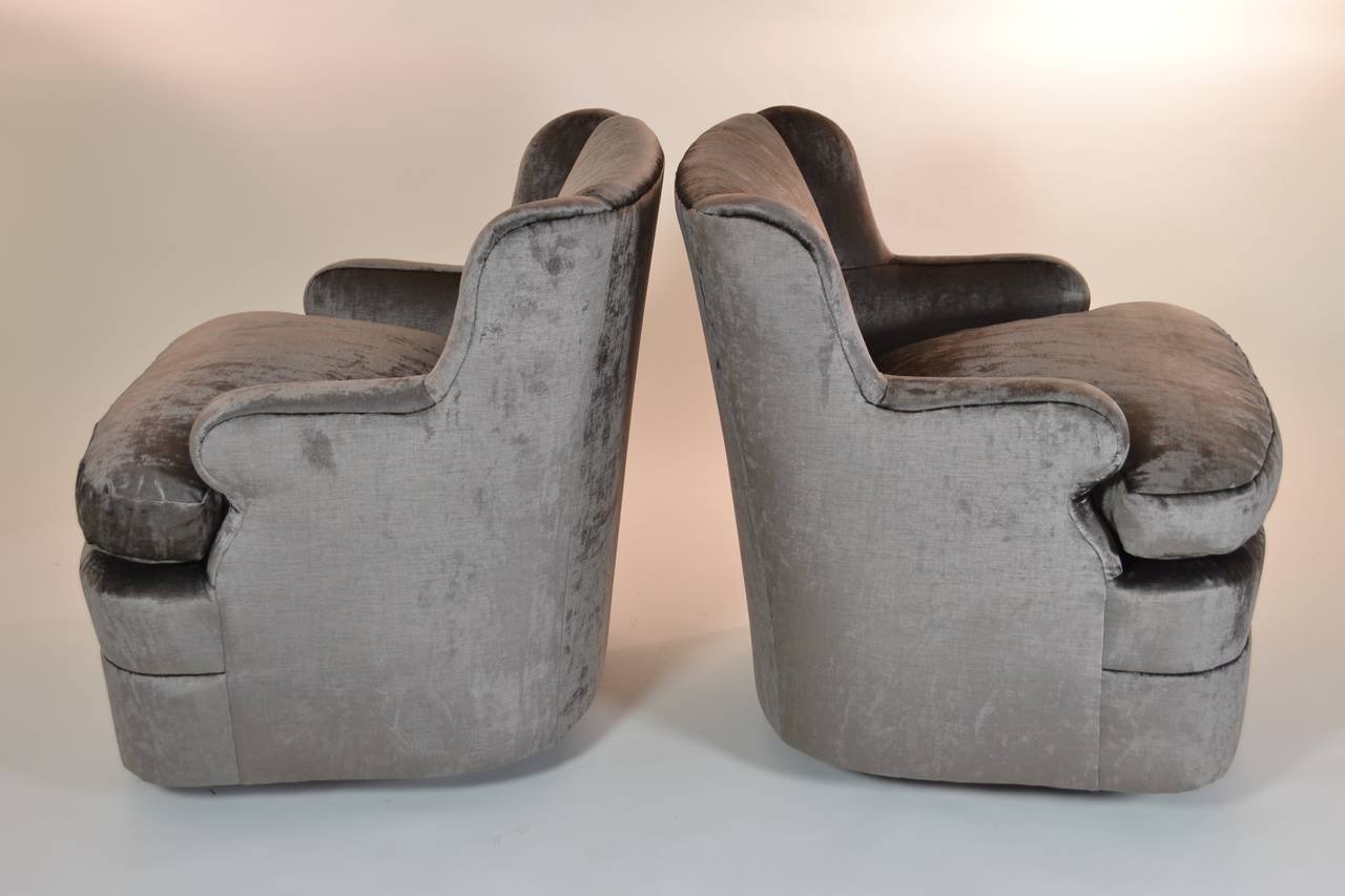Simple and stylish modern-form swivel lounge chairs. Tight back and loose seat cushion. Newly upholstered in satiny taupe velvet. Excellent condition.