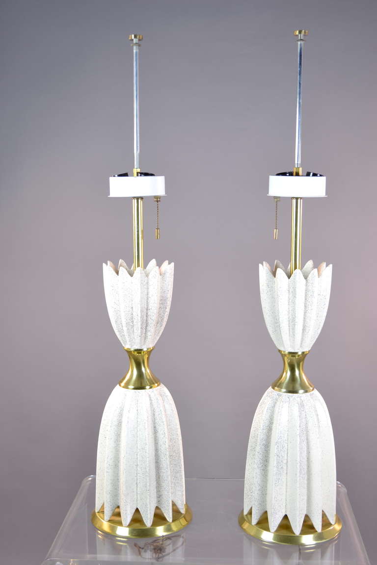 Designed by Gerald Thurston for Lightolier in the 1950s, this pair is in excellent condition with distinctive original lighting fixture fitting three standard bulbs with a three click chain pull. Original pull and tab, original finials. Measures: