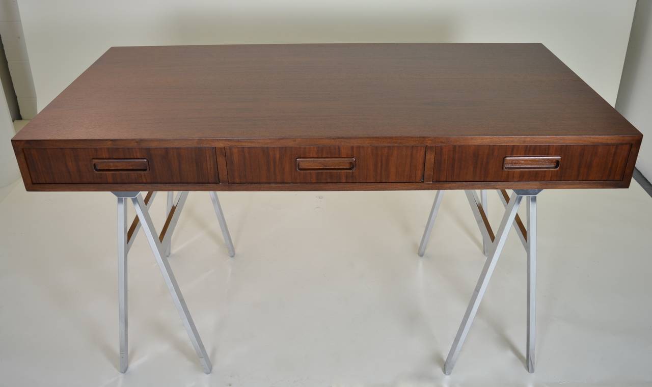 Rich, teakwood top with three drawers on saw-horse style chrome legs. Wood top beautifully refinished. Solid and sturdy. Finished all around including back so may be floated in the room.