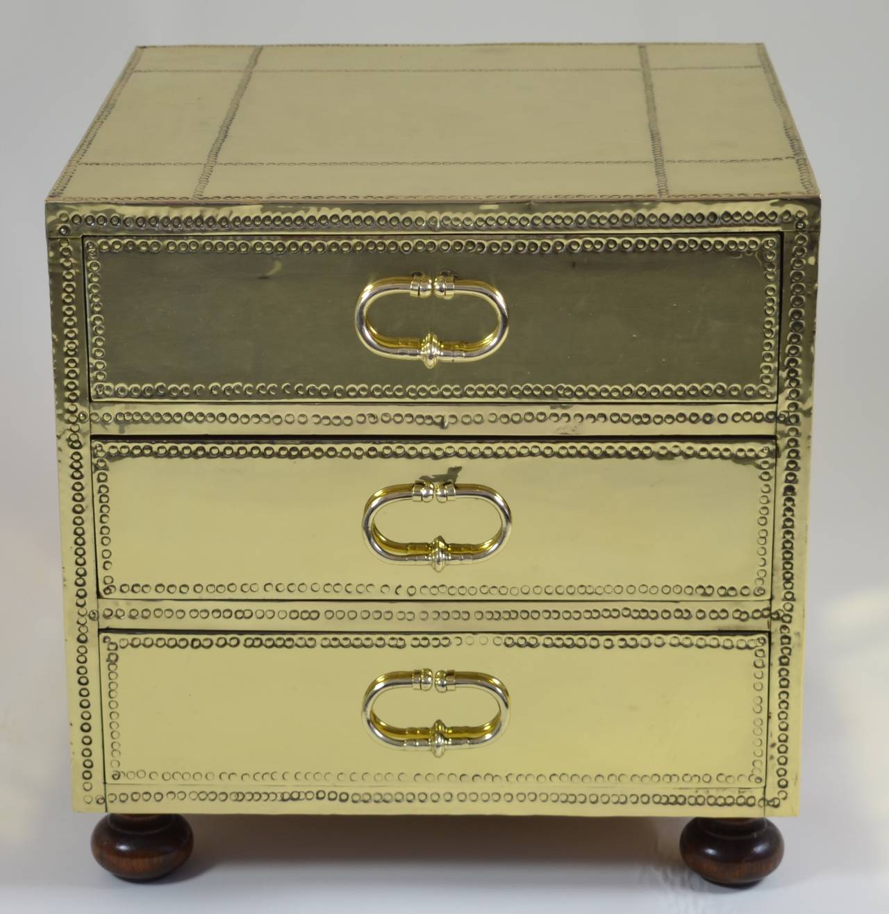 Sarreid three-drawer small brass-clad chest. Featuring three wood drawers and bun feet. Great quality and a very useful size. Professionally polished and lacquered.