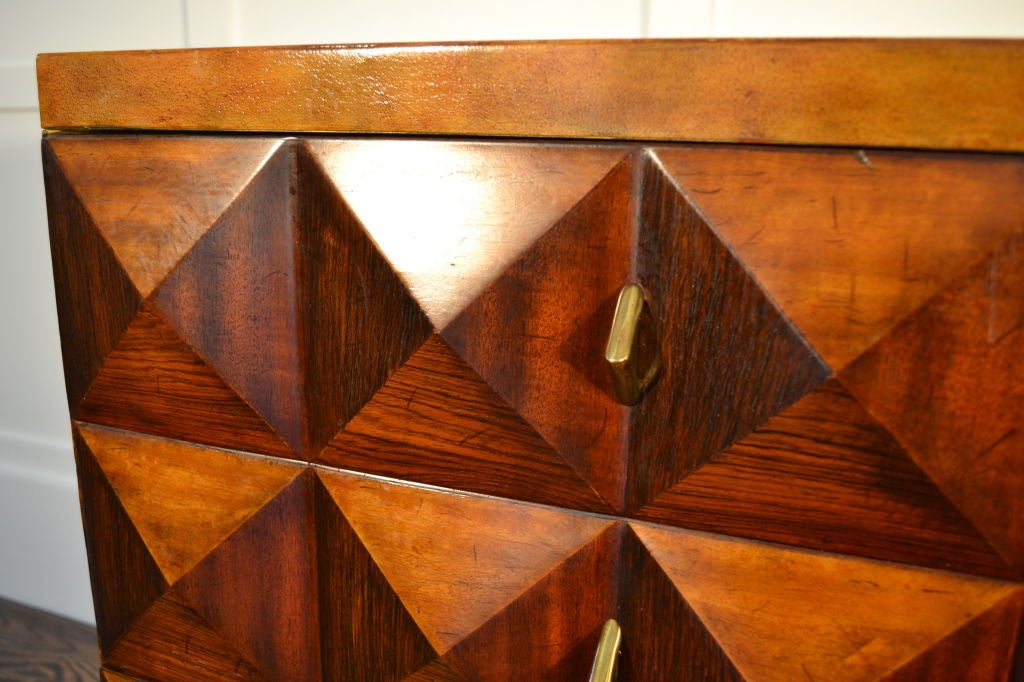 This distinctive commode from Maitland-Smith has a raised pyramid pattern on three sides --each pyramid combining panels of rosewood, satinwood and bonde mahogany. The top  and base are wrapped in tooled leather. <br />
<br />
The chest has 10