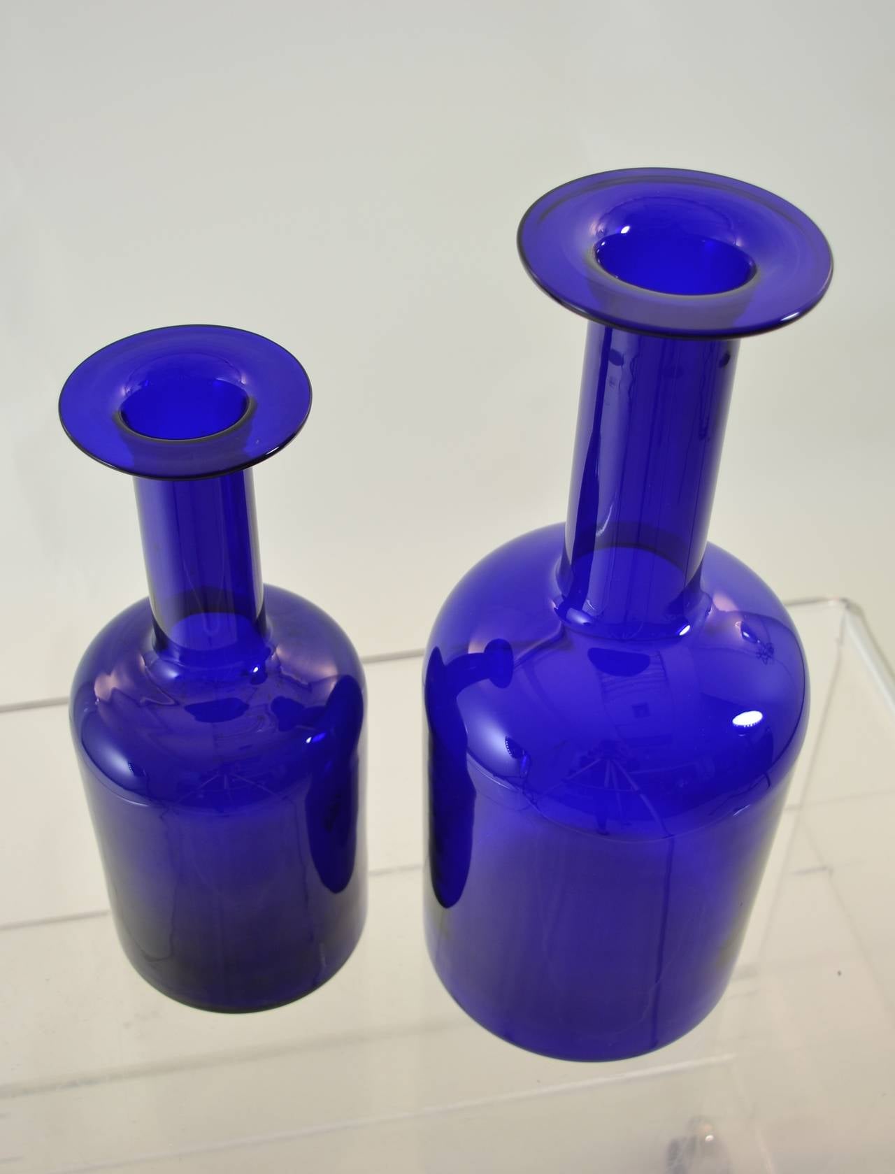 Wonderful deep cobalt glass in class Holmegaard vases. Two sizes: The larger: inches height, 5.75 inches diameter and the smaller: 12 inches height, 4.5 inches diameter.