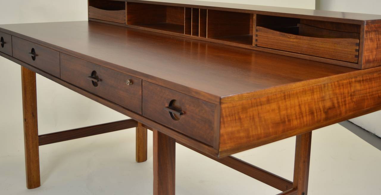 This iconic teakwood desk was made by Peter Lovig Furniture Company in Denmark in the 1960s. Purchased form the original owners it has been beautifully restored. It has the signature flip-down cubby with drawers and bins that can expand the flat
