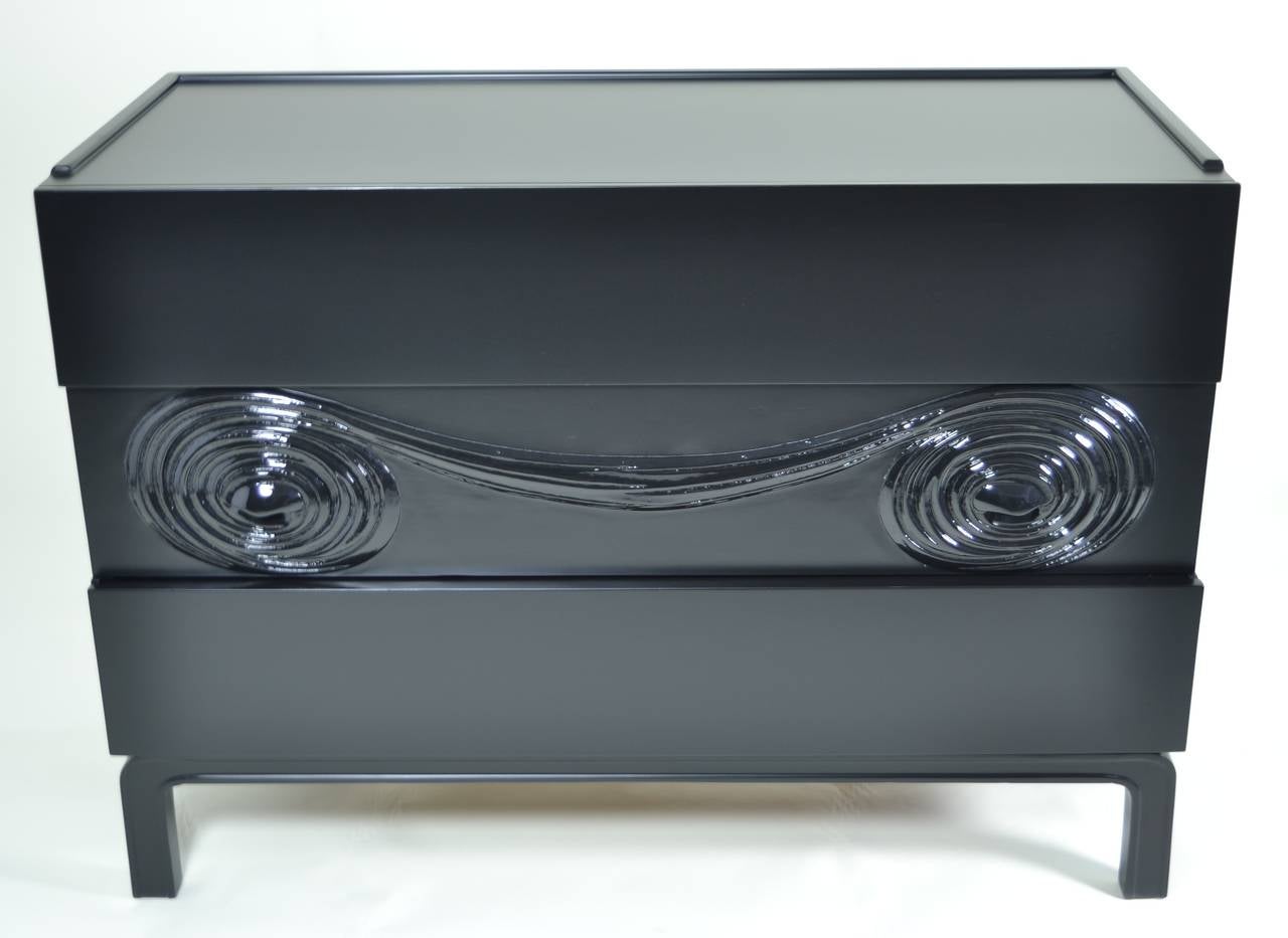 Newly lacquered in matte black with high gloss details, this is a chest made in Sweden and attributed to the American designer Edmund J. Spence. It has three drawers constructed of oak and an Asian-style base, circa 1950s.