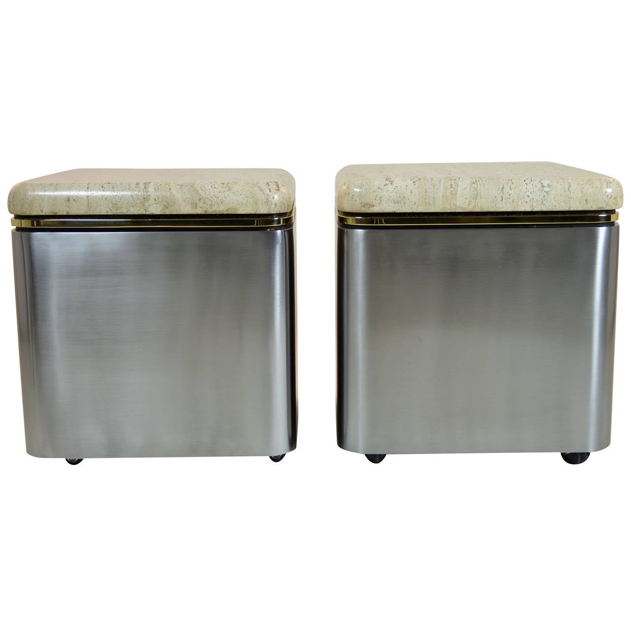 With elegant brass detail, satin steel and super thick travertine marble tops. Newly polished. Very fine quality. Each table is on heavy rubber casters and moves very smoothly.