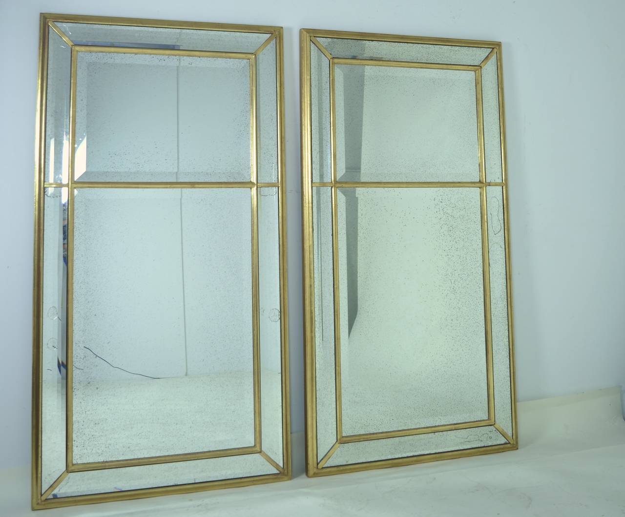 Part of the F. Schumacher Mirror line, this handsome pair of mirrors are super-fine quality. Beautifully water gilded with antiqued mirror glass and wide bevels. The surrounding mirror edges are faceted with multiple bevels.