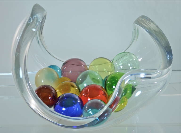 Large heavy lucite ogranic form bowl with a dozen multi-colored hand-blown glass balls. 
