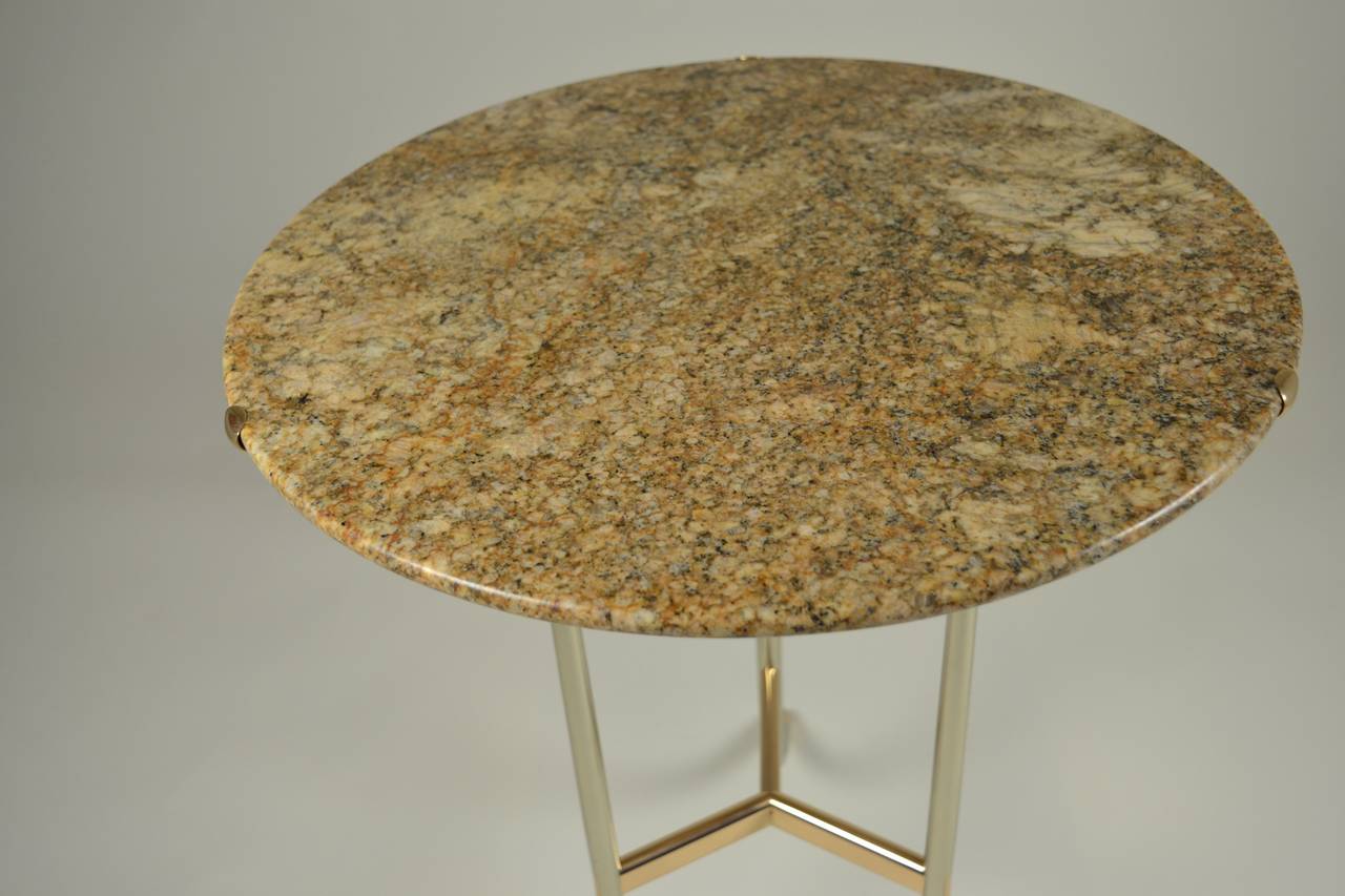 The base of this table is constructed like a piece of fine jewelry, beautiful craftsmanship and elegant design. The top is beautifully polished stone in creams and browns. Signed and numbered on underside. Excellent condition. Diameter of top is