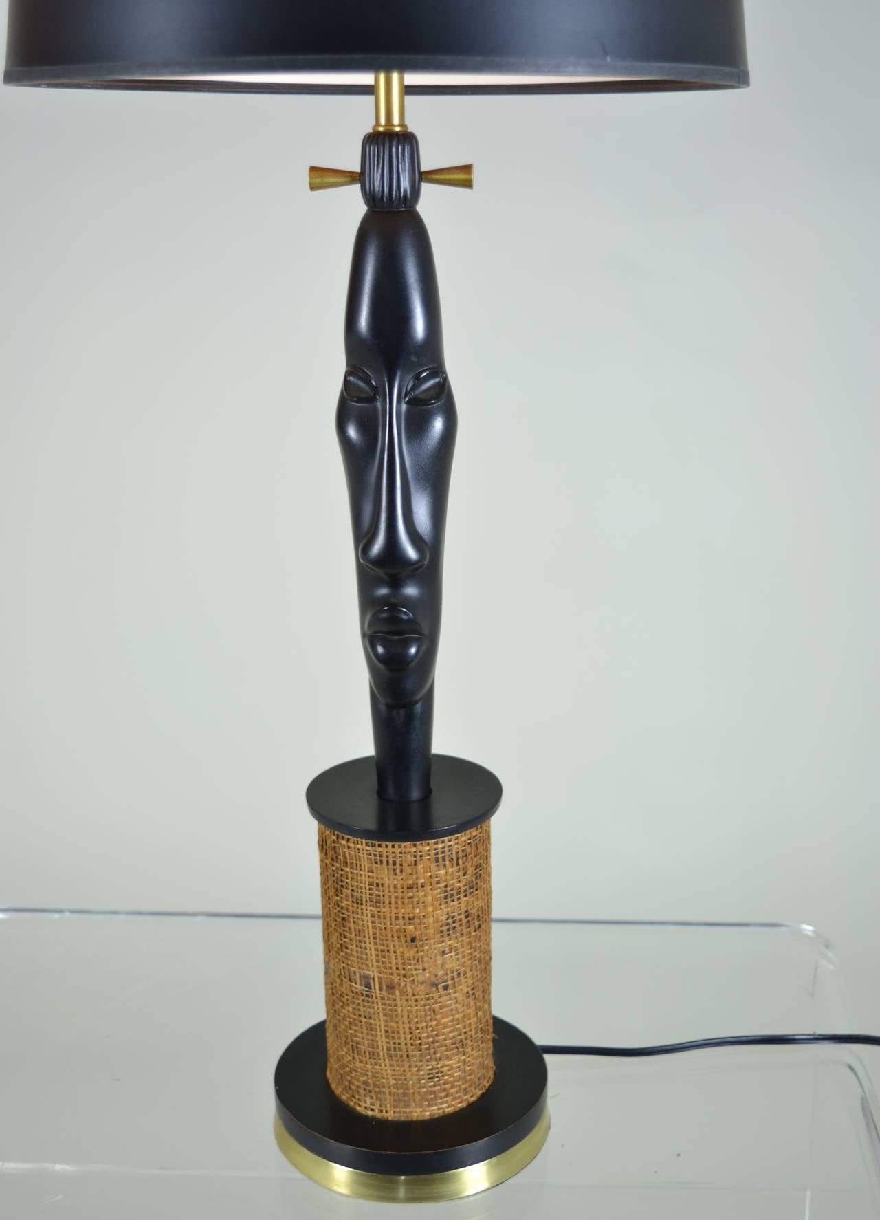 Sculptural lamp with African inspired carving. Super quality, black and brass base with grass cloth cover and brass details. All new wiring. Height to top of final w/harp shown: 30.75; 25.5 to top of socket.
