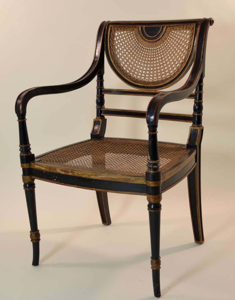 Handsome Regency details including caned fan-back and figured saber on this fine quality chair. Caned seat with custom boxed cushion in camel velvet. Circa 1920s