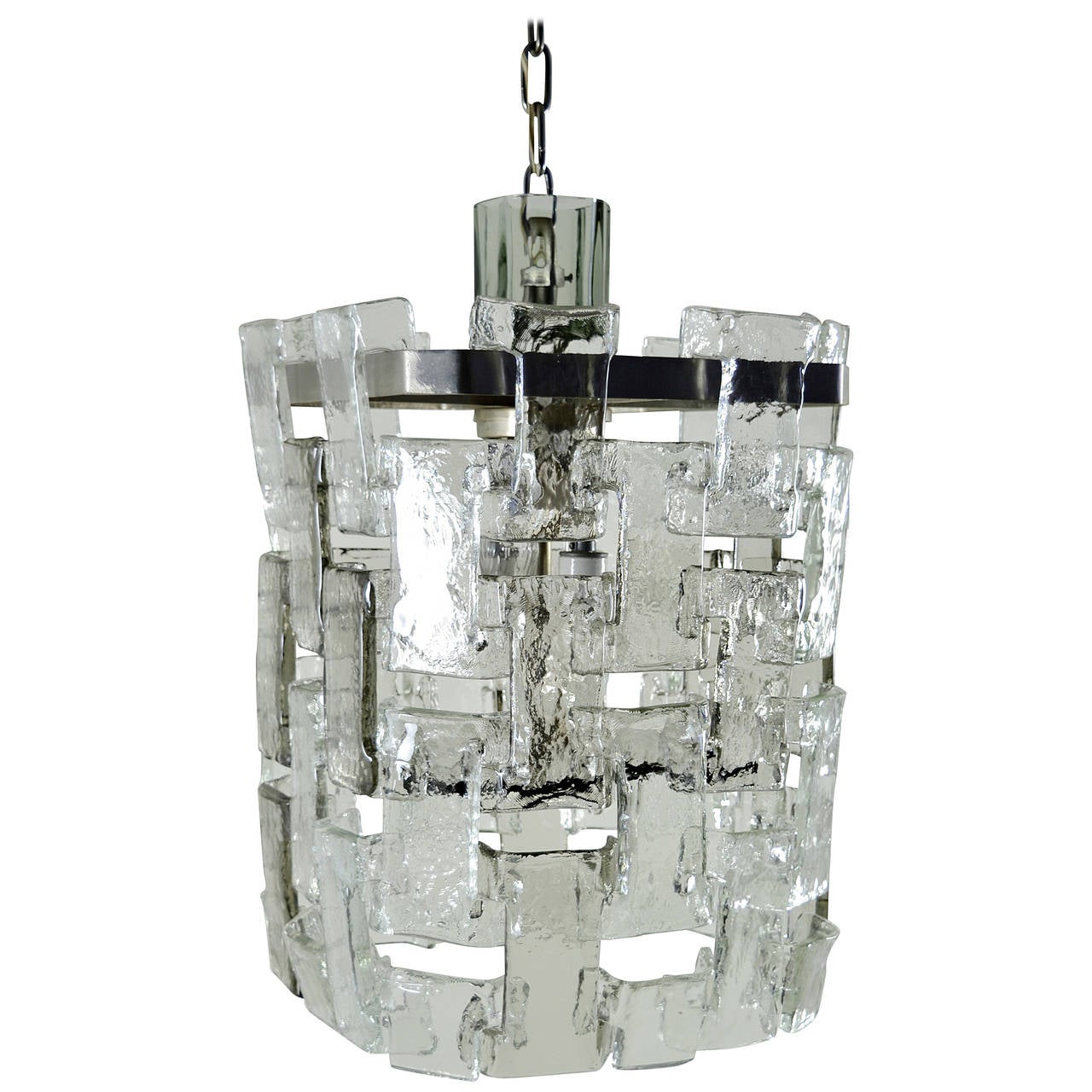 Handsome Mazzega chandelier featuring interlocking molded glass sections, clear and slightly smoked. Fixture has four lights hidden from below by glass plate and glass cover over the attachment to chain. Purchased early 1970s. Included is original