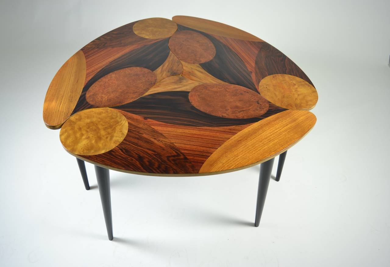 Unusual and beautiful form. Three tables in organic shapes that fit together. Tops are decorated with multiple woods: Rosewood, burled maple, walnut, mahogany. Finished in beautiful hand rubbed, high-gloss lacquer. Legs are lacquered satin black.