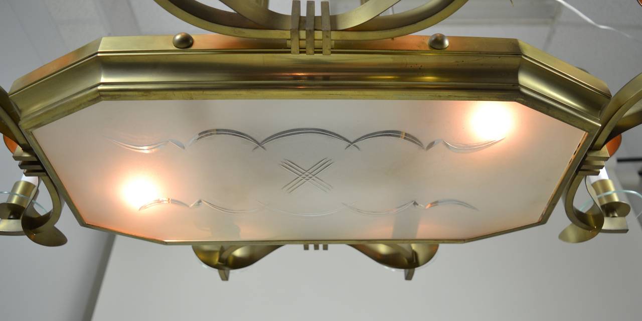 Amazing quality chandelier in solid brass-even the shades. Art Deco style details, etched glass insert, clear glass rods between brass rods supporting the fixture, and simple clear glass bobeche. Fully rewired. Dimensions: 35