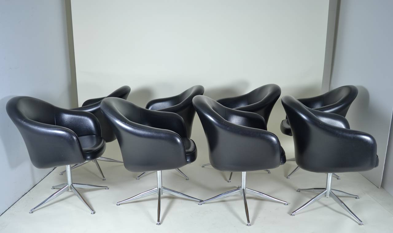 Classic form and very comfortable. A nice set of eight chairs with simple chrome bases and rounded barrel shaped chair, upholstered in quality faux leather. Original cover but very clean.