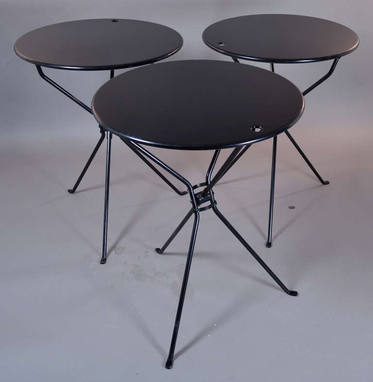 Three enamel coated steel cafe tables made to fold flat for easy storage. Superb design and functionality. Minor surface scratches --generally excellent condition.