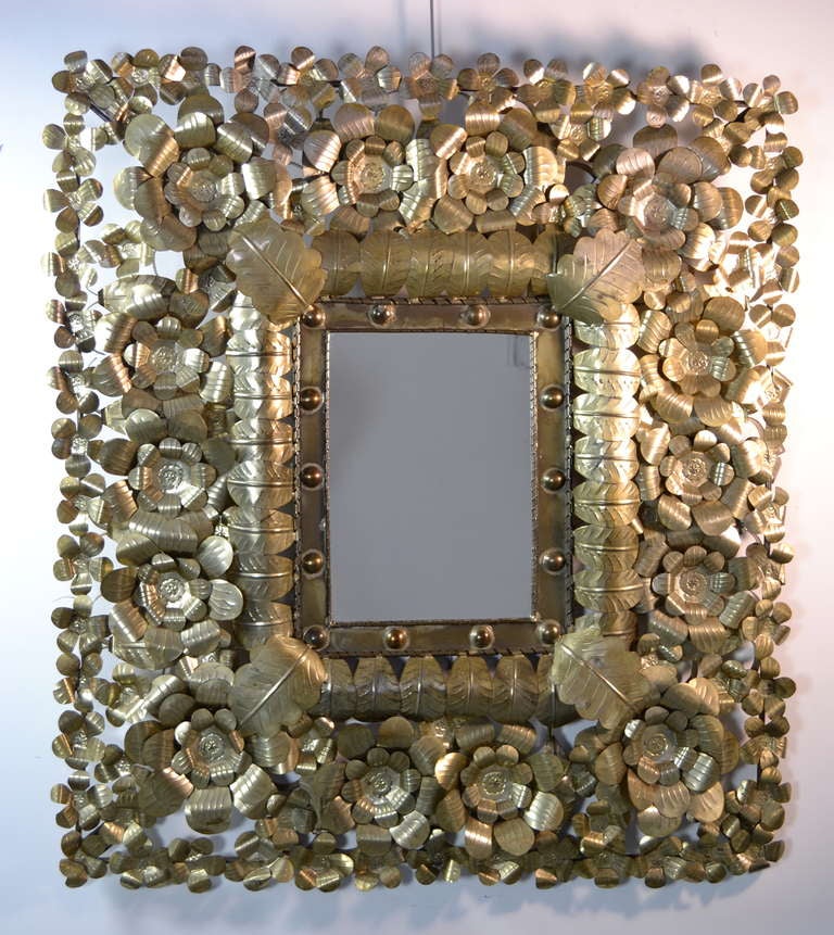Fanciful, elaborately festive mirror with intertwined gold-tone tin flowers and leaves. Impressive rarely seen large size.