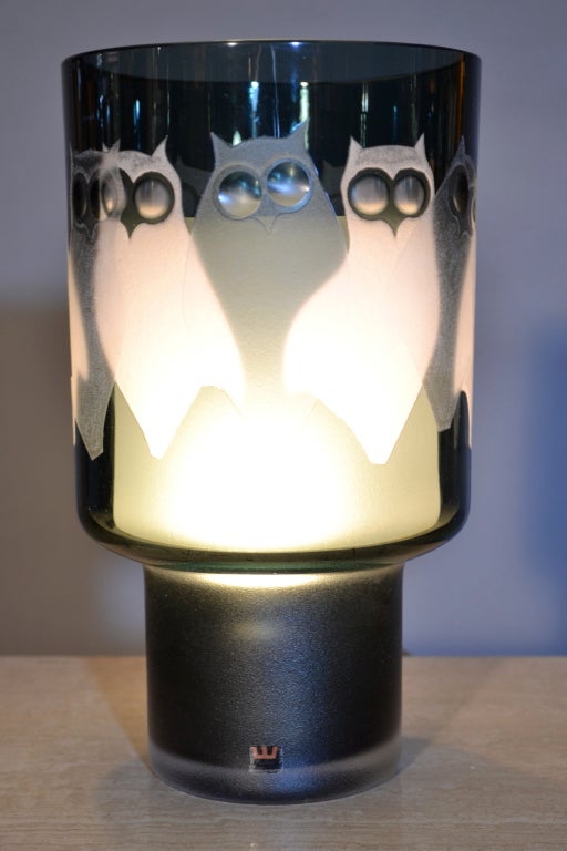 Charming glass lamp by Kosta made in the early 1970s. The outer glass features etched owls repeating all around the upper cylinder. The bulb sits in the base but is covered by an glass shade that inserts from the top. It has been completely rewired