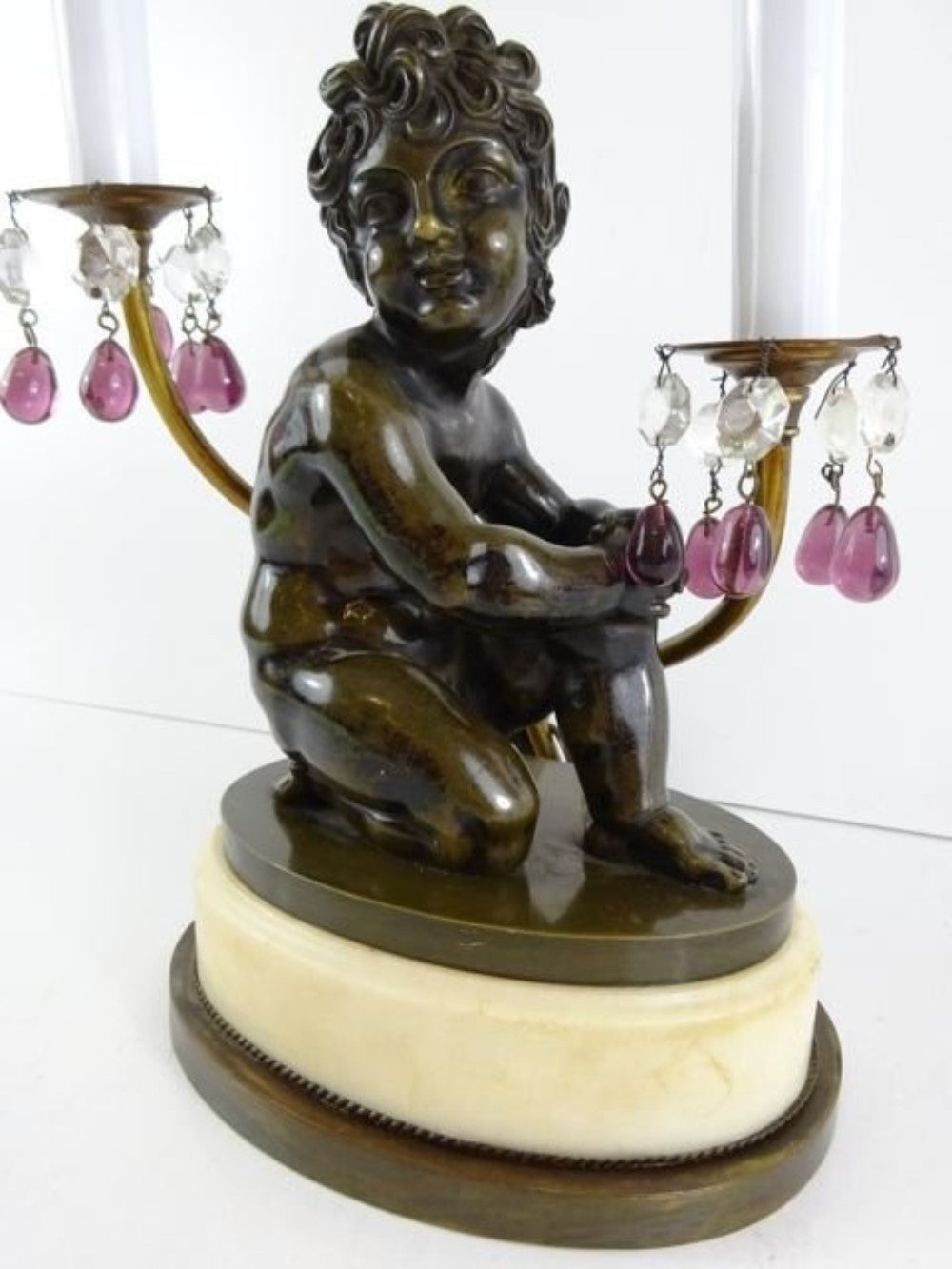 Art Deco lamp of a seated figure with two lights and multi colored crystals, raised on a marble plinth,  Bronze figure is unsigned.