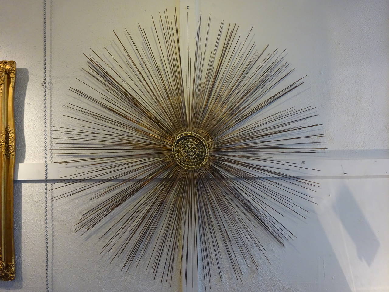 A monumental metal starburst wall sculpture by Bruce and William Friedle. A stunning and dramatic piece.