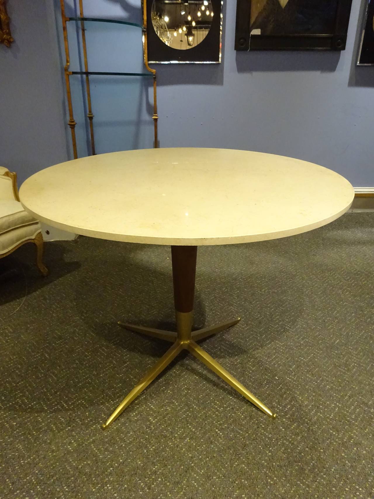 Dining table in the style of Gio Ponti, with circular marble top and wood and brass-mounted base.