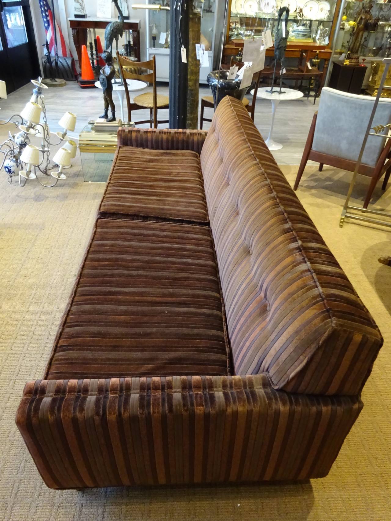 Sofa in the Style of Paul McCobb, of rectangular form raised on three front legs, supporting the rectangualr tuxedo style sofa with two cushions. Upholstery is vintage and in very good condition.