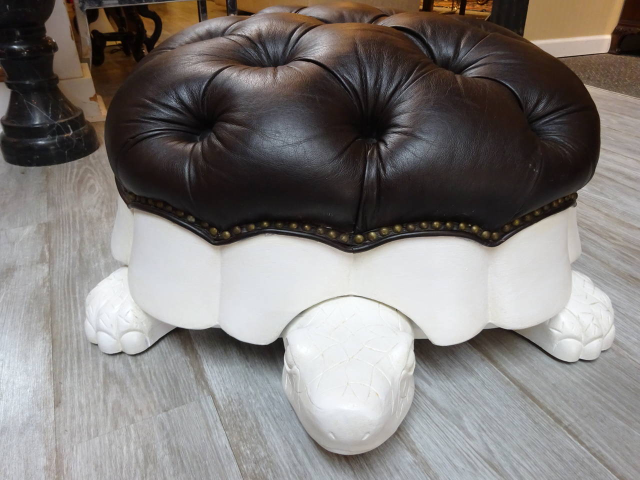 Leather turtle ottoman, realistically modeled of polychromed carved wood, with tufted leather cushion.