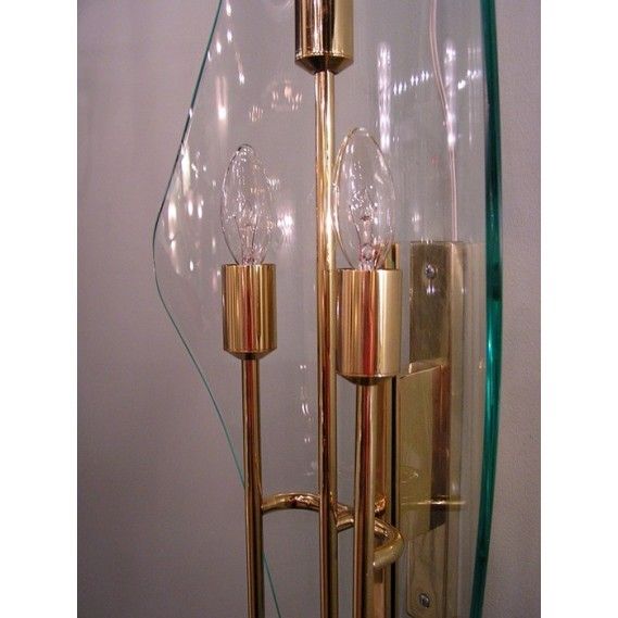 A truly impressive and documented pair of 1950s wall lights with curved glass shield backsplate. Designed by Max Ingrand for famed Italian glass house Fontana Arte. Each sconce holds three candelabra lights. Brass polished and lacquered. Rewired.