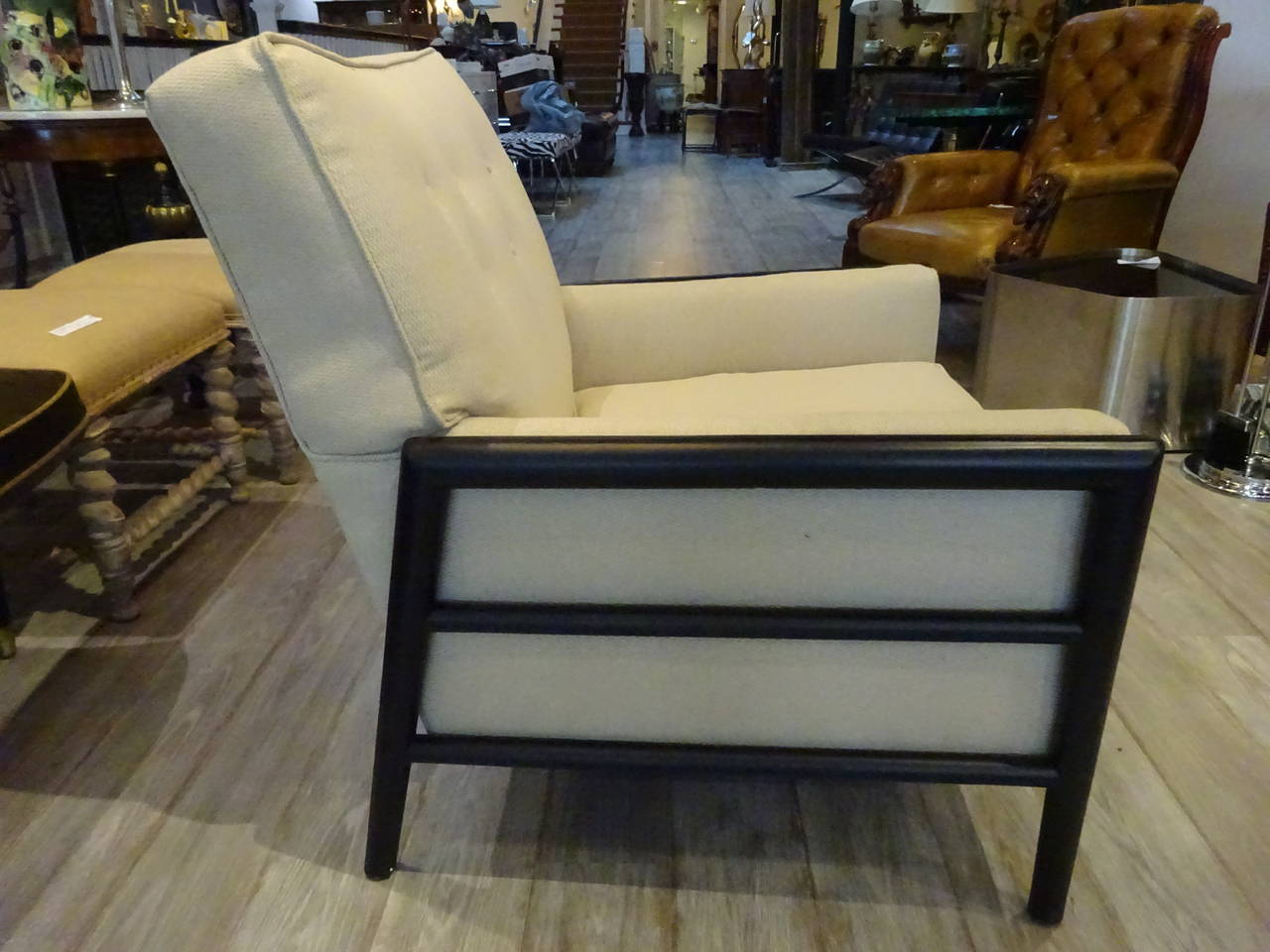 T.H. Robsjohn-Gibbings club chair, with ebonized side rails and recent neutral upholstery.